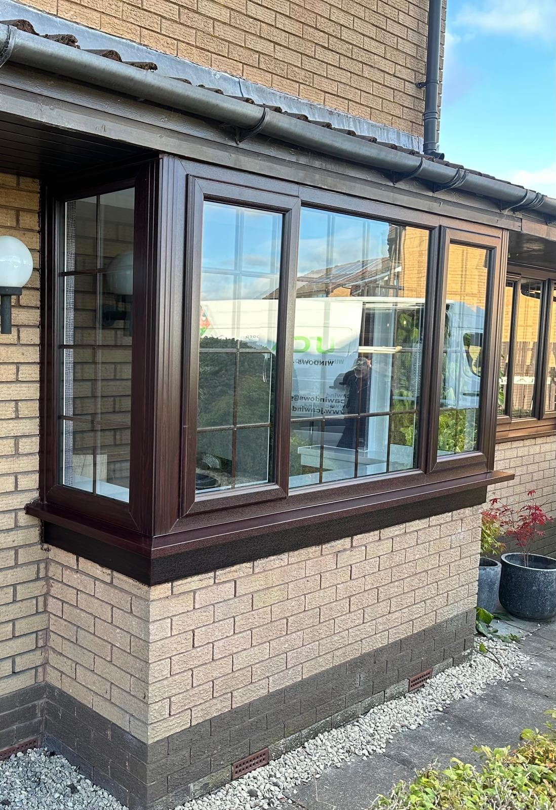 Brown framed bay window installation